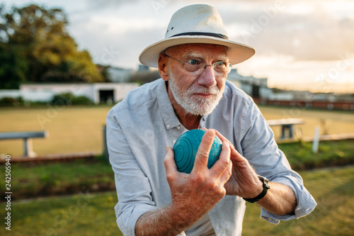 Elderly man playing a game of boules photo