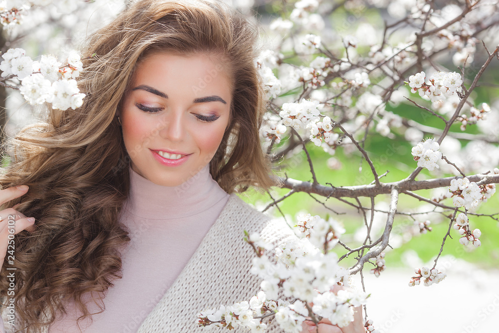 Young attractive woman on spring background with flowers. Close up portrait of beautiful girl make up. Lady outdoors in the garden Young attractive woman on spring background with flowers. Close up portrait of beautiful girl make up. Lady outdoors in the garden