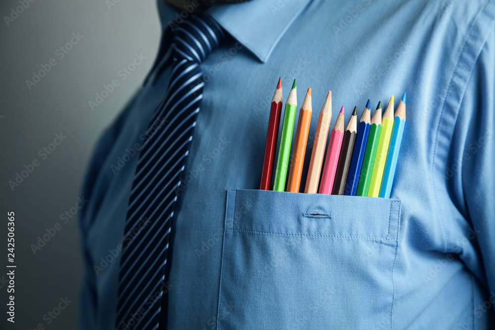 Businessman in blue shirt with colorful pencils in pocket. - obrazy, fototapety, plakaty 