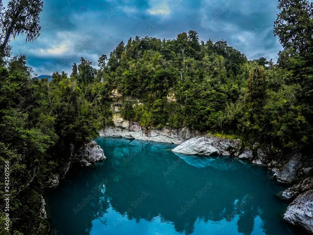 Panorama landscape view of tourist popular attraction/destination Hokitika Gorge on West Coast, South Island, New Zealand. Breathtaking scene of turquoise clear river water and green trees around- 
