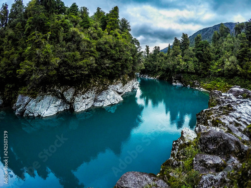 Panorama landscape view of tourist popular attraction/destination Hokitika Gorge on West Coast, South Island, New Zealand. Breathtaking scene of turquoise clear river water and green trees around- 