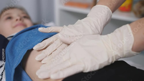 The doctor palpated the abdomen of a young patient in a medical office., close-up.