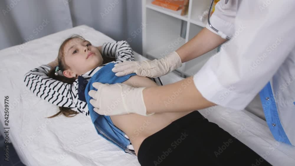 Bác sĩ nữ đang khám bụng của một bệnh nhân bé gái trong ...        