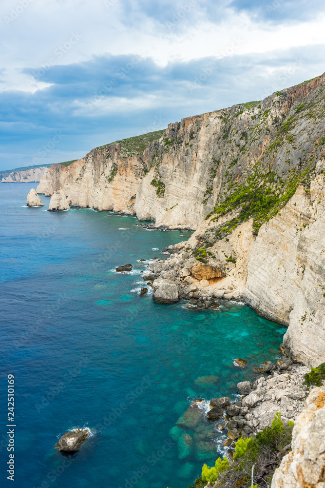 Greece, Zakynthos, Rough chalk rock cliff coastline next to perfect turquoise water