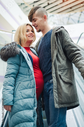 Pregnant wife and husband spend time together in shopping center