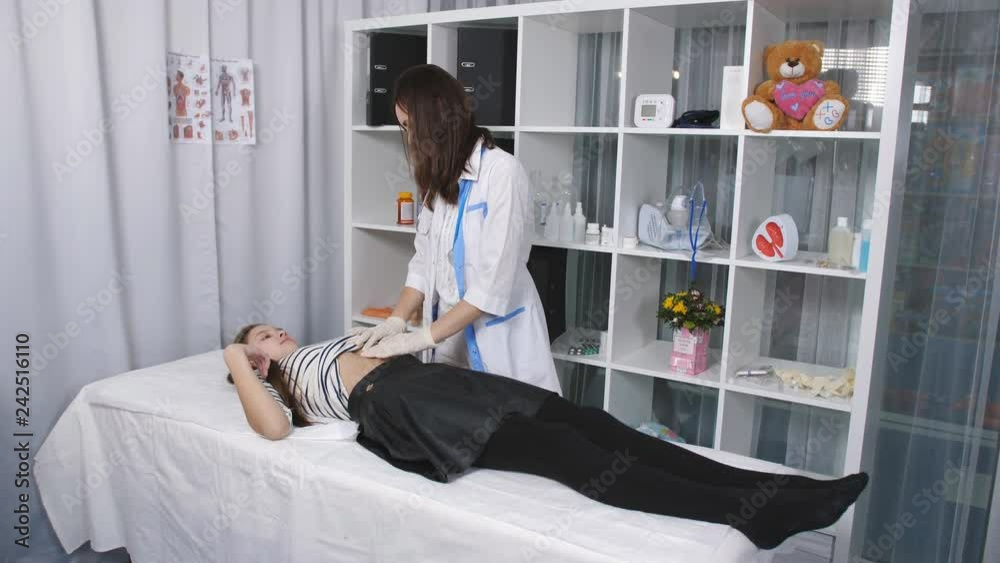 Female doctor makes teen girl massage in the clinic office Female doctor makes teen girl massage in the clinic office