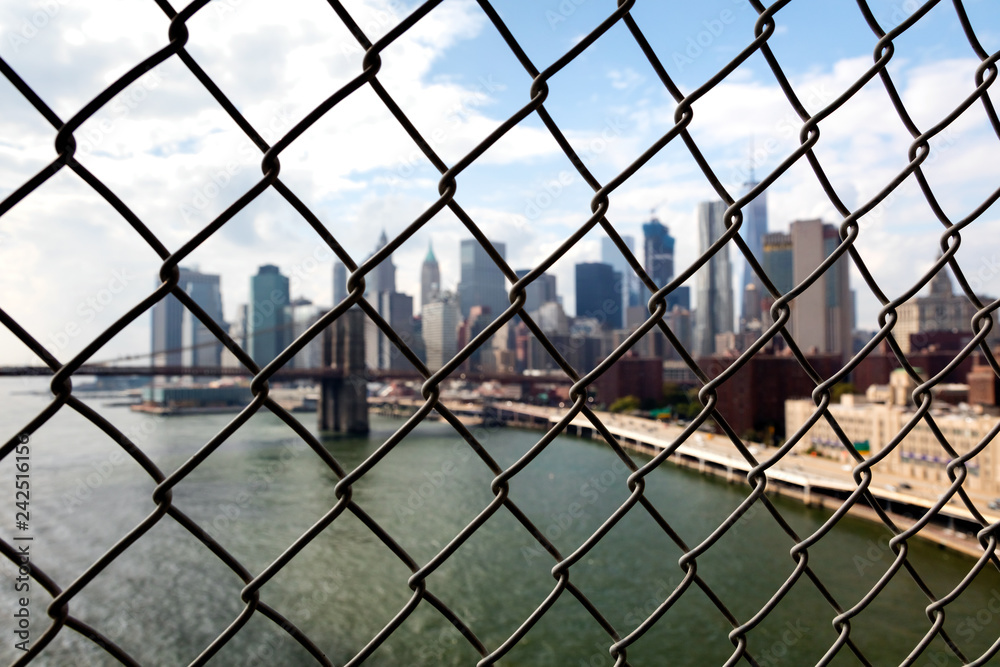 New York Brooklyn Bridge and Downtown through the wired mesh New York Brooklyn Bridge and Downtown through the wired mesh