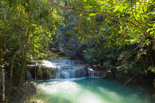 Jangle landscape with flowing turquoise water of Erawan cascade waterfall