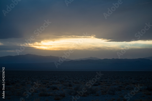 God rays burst through the clouds in this evening panorama of Death Valley National Park
