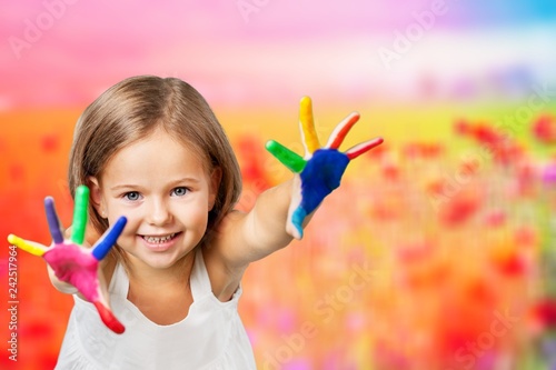 Cute little girl with colorful painted hands on white background