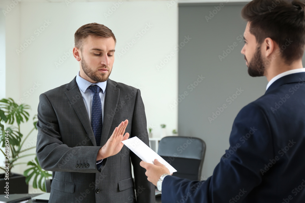 Businessman refusing to take bribe in office. Concept of corruption Businessman refusing to take bribe in office. Concept of corruption