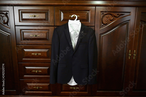 Wedding concept. The suit of the groom on the hanger. Wedding wear, accessories