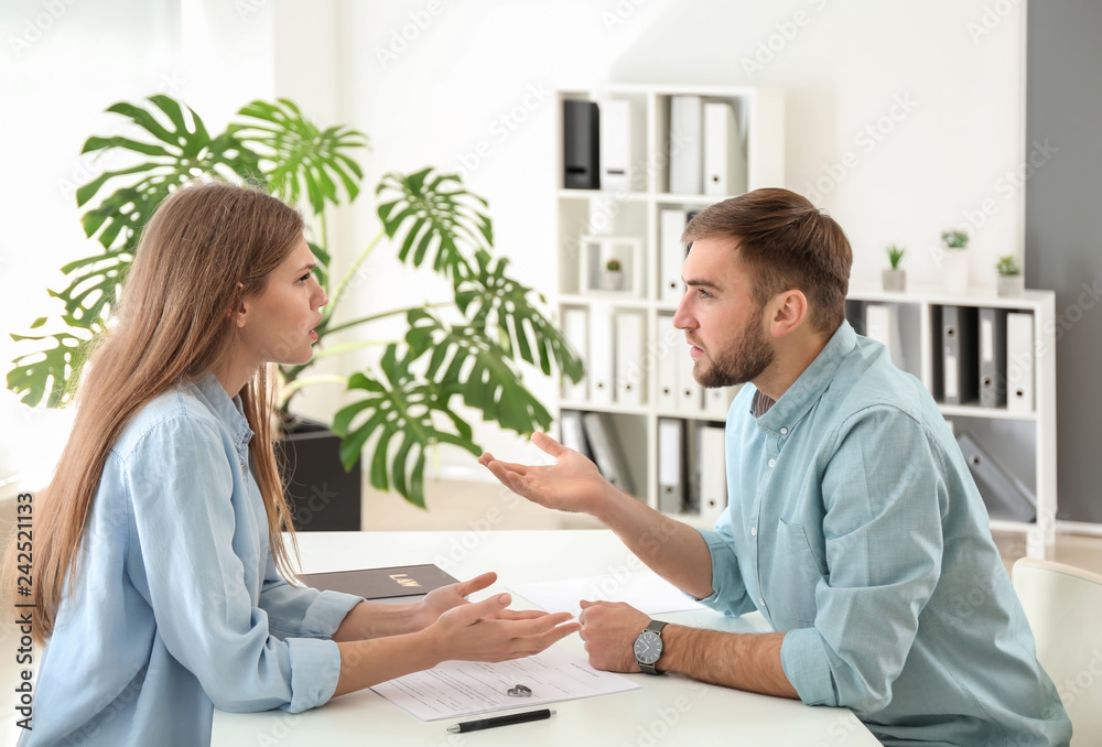 Obraz premium Young emotional couple visiting divorce lawyer in office