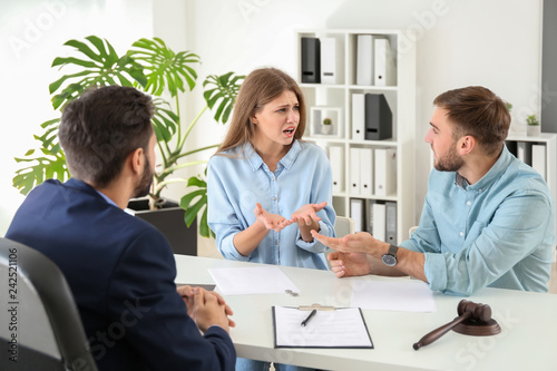 Young emotional couple visiting divorce lawyer in office