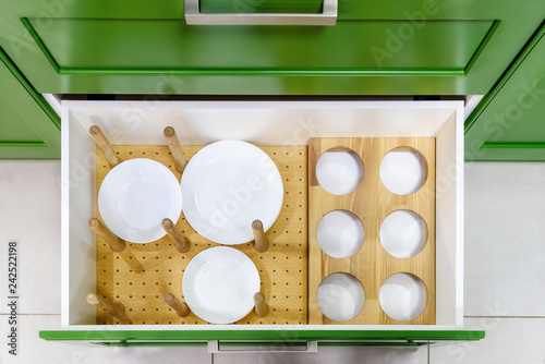 Kitchen furniture in green with open drawers