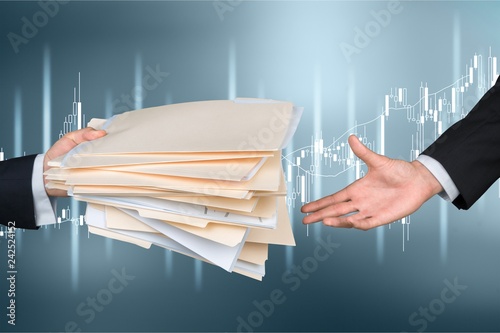 Hands of businessmen holding documents on background