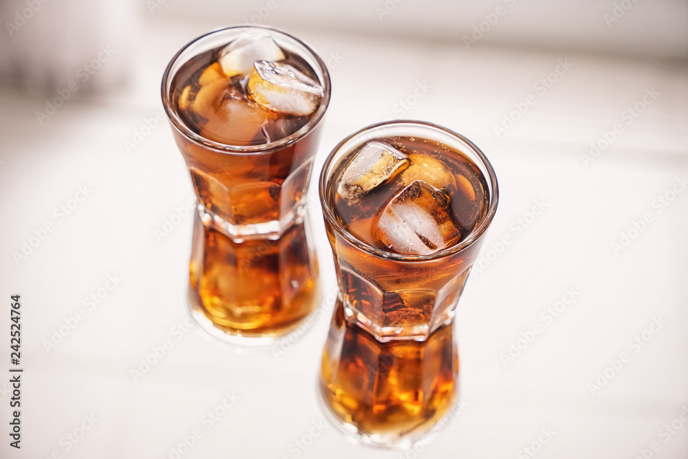 Glasses of tasty cold cola drink on light table Glasses of tasty cold cola drink on light table