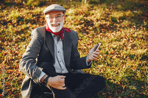 Elegant old man in a sunny autumn park 