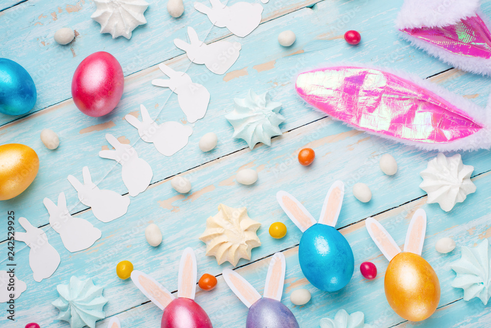 Easter colored eggs with ears of sweets and rabbit ears. Fly lay lay. Easter festive background.