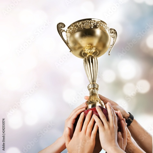 Hands holding a champion golden trophy on white background