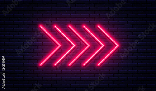 Neon arrow sign. Glowing neon arrow pointer on brick wall background. Retro signboard with bright neon tubes