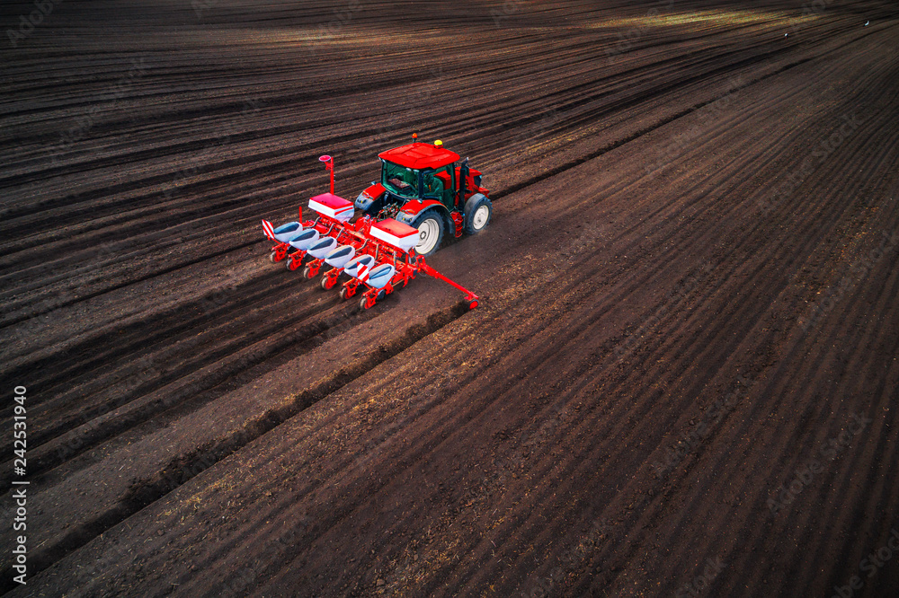 Obraz premium Farmer with tractor seeding crops at field, aerial drone view