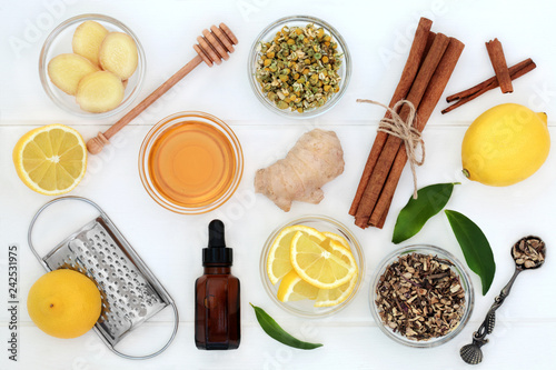 фотографія Ingredients for cold and flu remedy with ginger and cinnamon spice, eucalyptus aromatherapy oil, lemon fruit with honey on white wood background