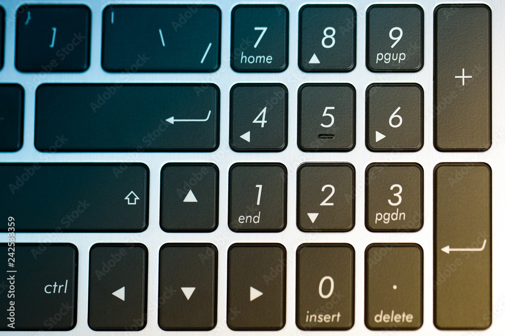 Close up of the laptop keyboard. Black keys on a light silver background. scratched texture background. The concept of business and information technologies. copy space. background for design. Toned Close up of the laptop keyboard. Black keys on a light silver background. scratched texture background. The concept of business and information technologies. copy space. background for design. Toned
