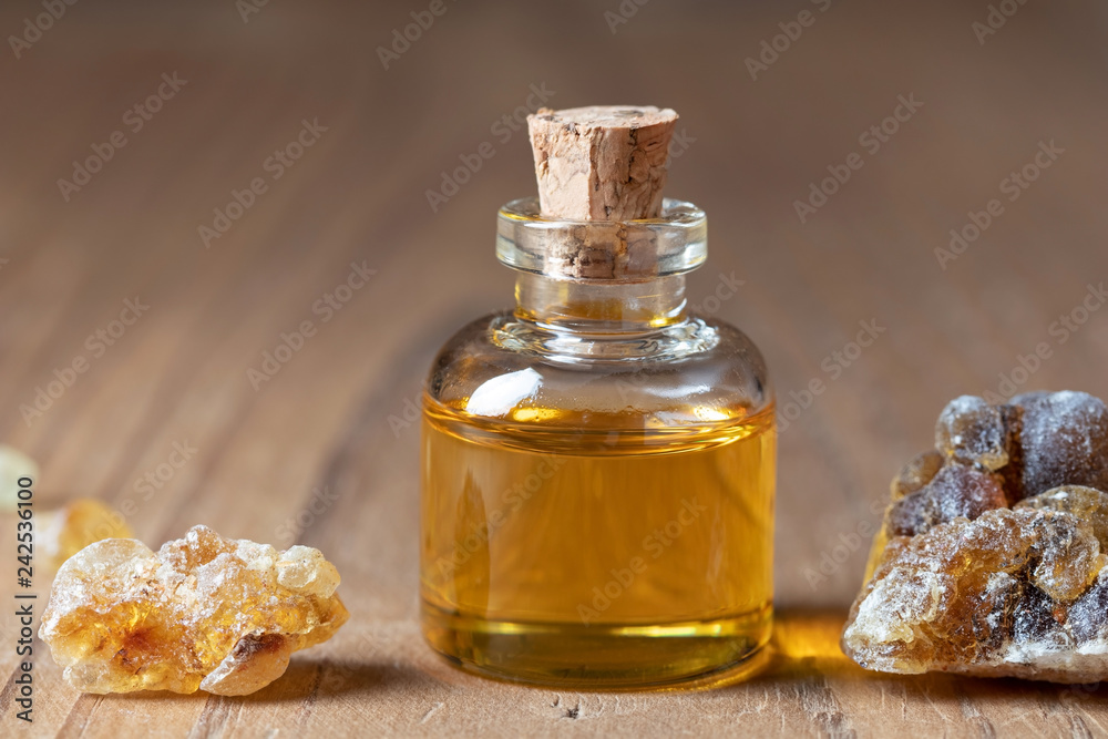 A bottle of frankincense essential oil with frankincense resin A bottle of frankincense essential oil with frankincense resin