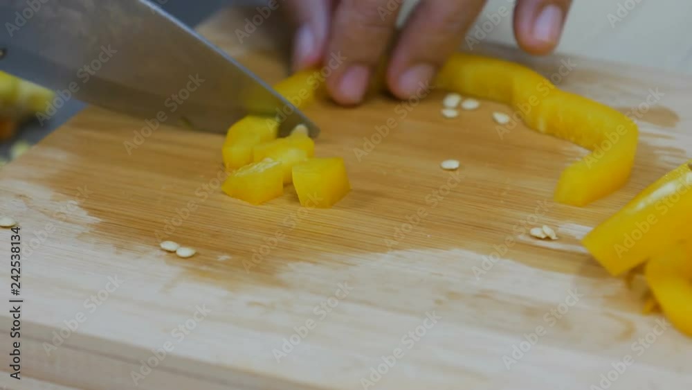 Close up shot Hands of woman using kitchen knife slice and cut the bell pepper vegetable preparing for cooking a food Close up shot Hands of woman using kitchen knife slice and cut the bell pepper vegetable preparing for cooking a food