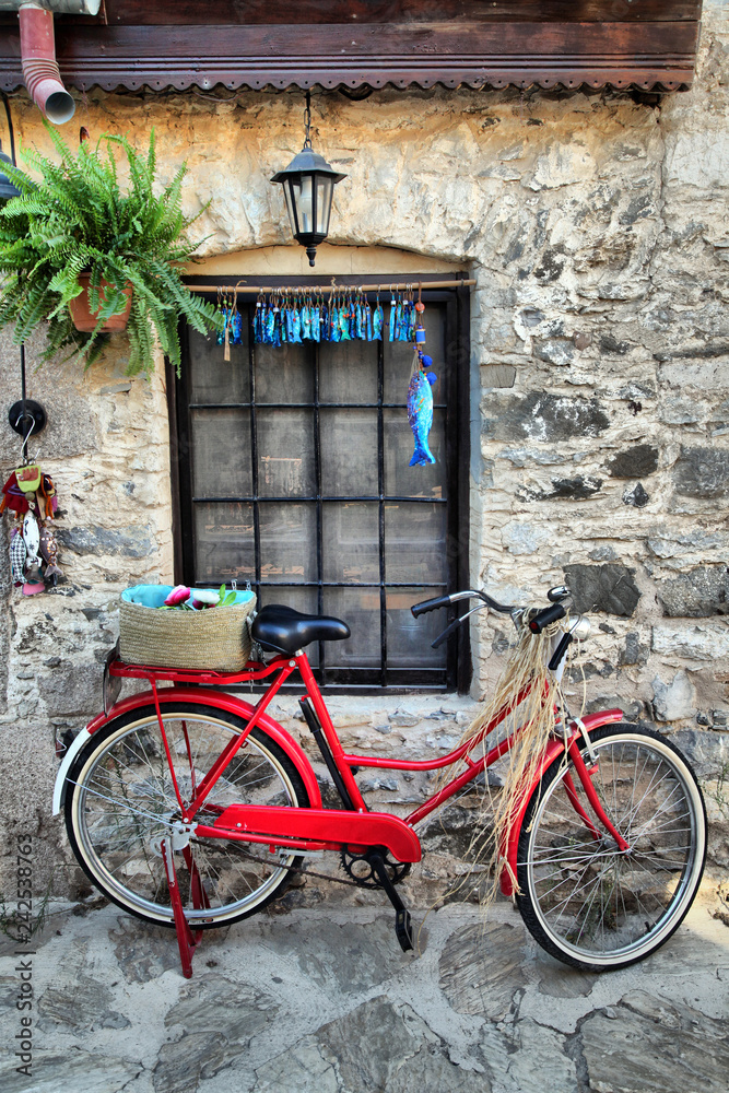 a red old bicycle against a stone wall in Old Datca street, Mugla, Turkey