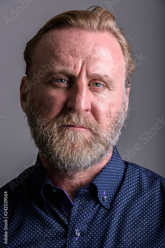Face of mature bearded man in gray background