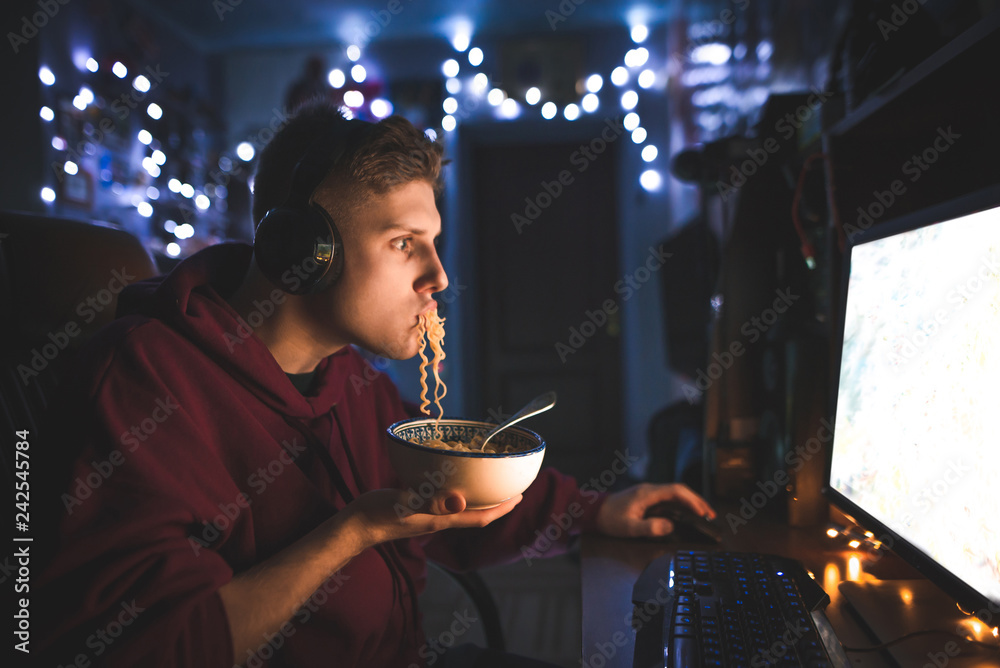 Portrait of an emotional man playing video games at night on a computer ...