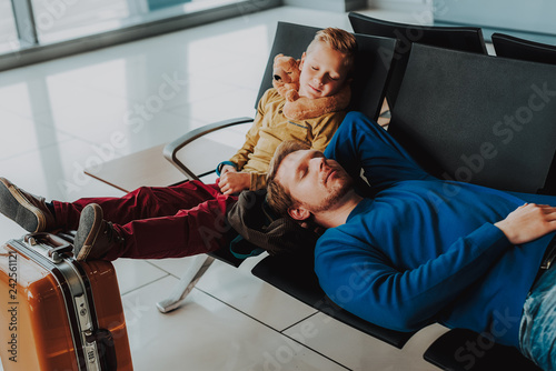 Father and son are sleeping in airport lounge
