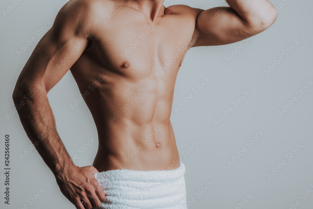 Foto Stock Slim muscular man posing with towel on hips | Adobe Stock