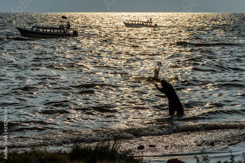 Boats & fisherman in late afternoon light, Lake Atitlan, Guatemala photo