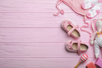 Flat lay composition with baby accessories and toys on color wooden background. Space for text