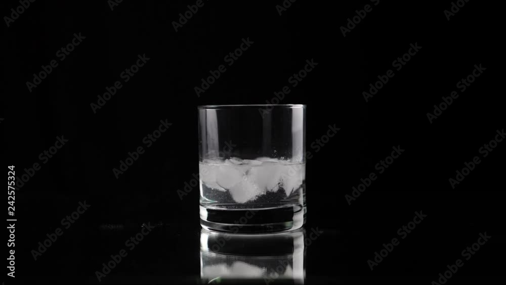 Mixing soda with cocktail straw in glass with ice, slow motion. Shallow depth of field Mixing soda with cocktail straw in glass with ice, slow motion. Shallow depth of field