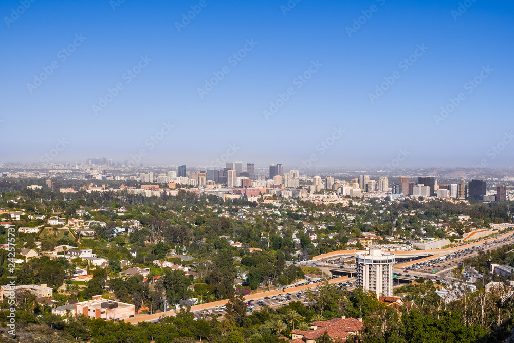 Aerial view towards the skyline of Century City commercial district; downtown area skyscrapers visible in the background; highway 405 and residential area in the foreground; Los Angeles, California