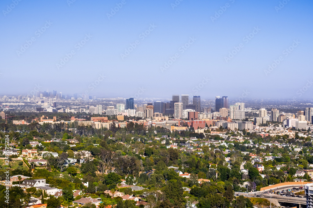 Aerial view towards the skyline of Century City commercial district; the downtown area skyscrapers visible in the background; residential neighborhoods in the foreground; Los Angeles, California