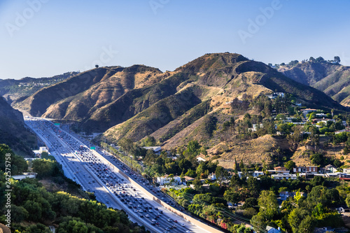 Aerial view of highway 405 with heavy traffic; the hills of Bel Air neighborhood in the background; Los Angeles, California