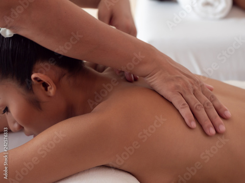 The masseuse's hands moving blur on the backs of Asian woman are a relaxing on bed. Massage and body care. Spa in salon