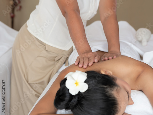 Asian woman are a relaxing on bed. backs massage in the Spa Salon. Thai massage for health. Select focus hand of masseuse