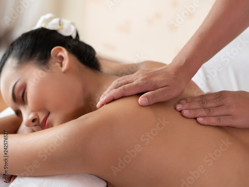 Hand of masseuse's on the backs of women. Asian woman are a relaxing on the bed. Massage and body care. Spa in salon