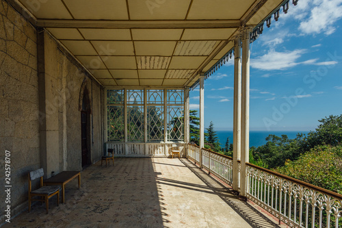 Abandoned mansion. Large decorated balcony with columns on sea coast