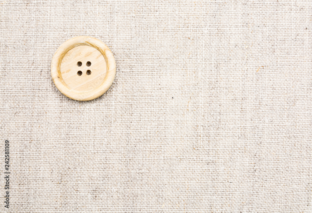 Large wooden sewing buttons with four holes on linen natural fabric Large wooden sewing buttons with four holes on linen natural fabric
