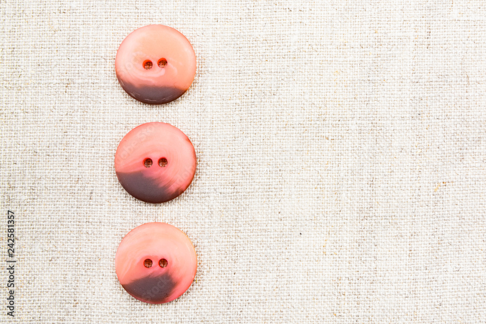 Large red sewn buttons on linen natural fabric Large red sewn buttons on linen natural fabric