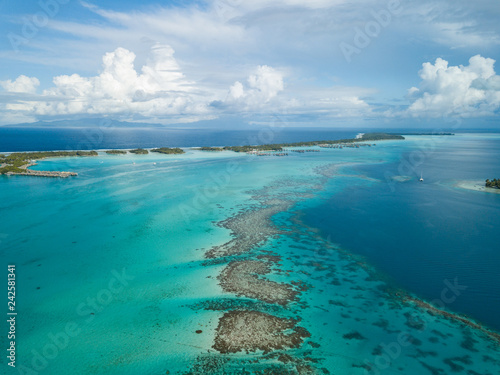 Luksusowe wille nad wodą z palmami kokosowymi, błękitną laguną, białą piaszczystą plażą na wyspie Bora Bora, Tahiti, Polinezja Francuska