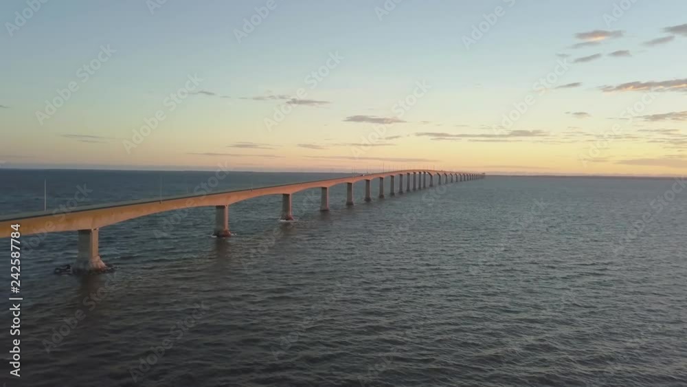 Aerial view of Confederation Bridge to Prince Edward Island during a vibrant sunny sunrise. Taken in Cape Jourimain National Wildlife Area, New Brunswick, Canada. Aerial view of Confederation Bridge to Prince Edward Island during a vibrant sunny sunrise. Taken in Cape Jourimain National Wildlife Area, New Brunswick, Canada.