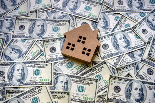Top view of financial investment concept with real estate business for growth to gain profit And residential with a house model placed on the background of dollar banknotes currency